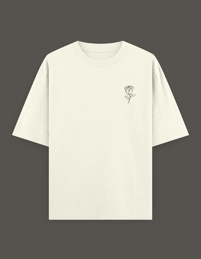 No Cap Co cream oversized fit t-shirt with a small black rose graphic on the left chest. Made from 240 GSM cotton-polyester blend.
